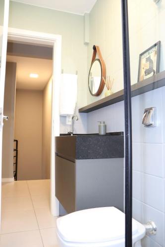 a bathroom with a toilet and a sink at Casa 700m Praia, Churrasq, SelfChekin, Garagem, Wi-fi, Ar, Portão Eletronico in Balneário Camboriú