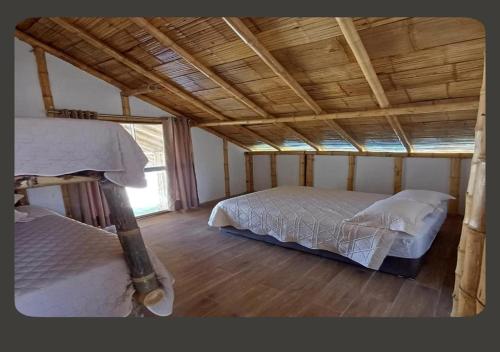 a bedroom with two beds and a wooden ceiling at Casa Dunas Vichayito in Vichayito