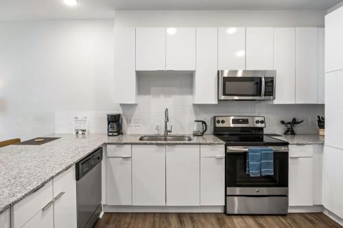 a white kitchen with a sink and a stove at Spectacular Apartments by BCA Furnished Apartments in Atlanta