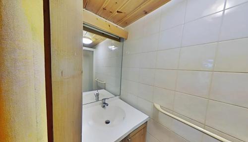 a white bathroom with a sink and a mirror at Casa-Chalet du Merle N° 2 in Champagny-en-Vanoise