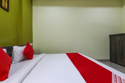 a red and white bed with red pillows on it at Hotel O Nabhyansh Elite Lokmanya Nagar railway station in Indore