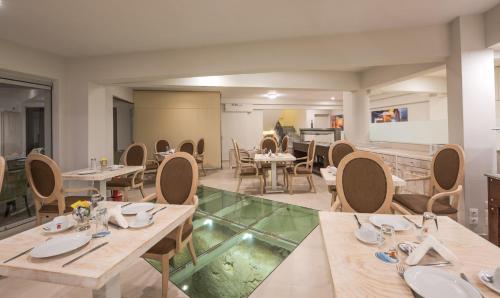 a restaurant with wooden tables and chairs and a room at Artemis Hotel Apartments in Hersonissos