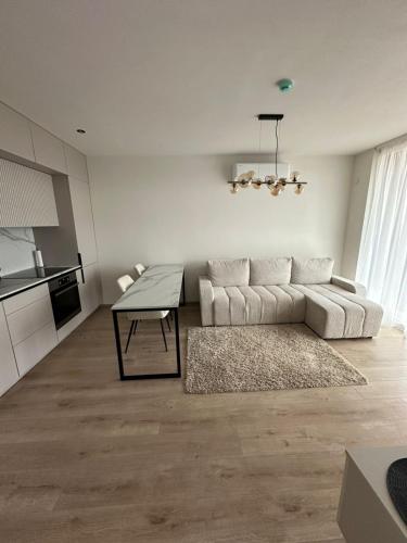 a living room with a couch and a table at Apartamentai INFINITUM SEA in Palanga