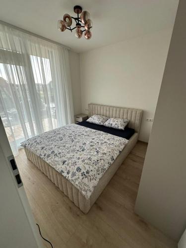 a bedroom with a bed and a large window at Apartamentai INFINITUM SEA in Palanga
