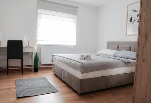 a bedroom with a bed and a desk and a window at Kuća za odmor Marof in Sveti Martin na Muri