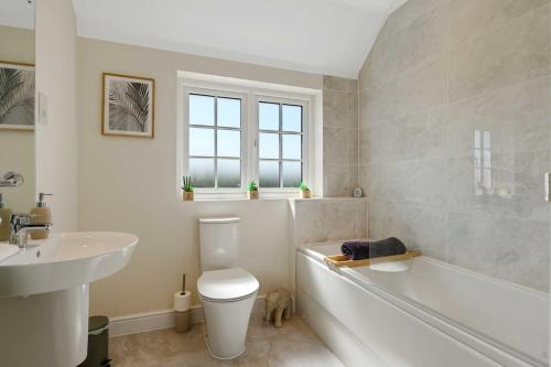 a bathroom with a tub and a toilet and a sink at 3 Bed HotTub House Donington EMA in Castle Donington