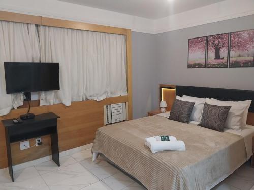 a bedroom with a bed and a flat screen tv at Flat Transamerica4 bela cintra com estacionamento in Sao Paulo