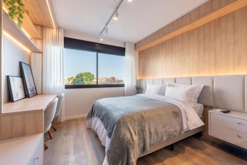 a bedroom with a bed and a large window at Skyline Parque Moinhos by LikeHome in Floresta