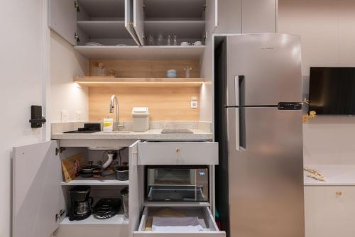 a kitchen with a stainless steel refrigerator at Skyline Parque Moinhos by LikeHome in Floresta