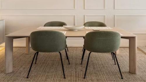 a wooden table with two green chairs around it at Private Villa Houlakia Mikonos in Agios Stefanos