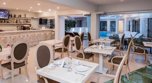 un restaurante con mesas y sillas y un bar en Artemis Hotel Apartments, en Hersonissos