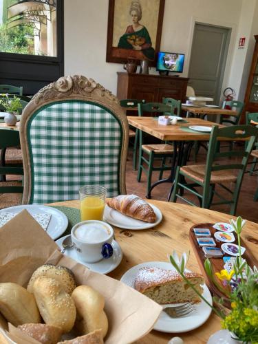 un tavolo con pane e succo d'arancia e un tavolo con cibi per la colazione di Al Rustico a Torbole