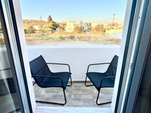 three chairs sitting on a balcony looking out the window at Aqualis in Adamas