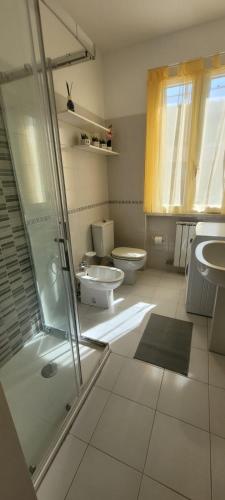 a bathroom with two toilets and a glass shower at La Chicca in Ameglia