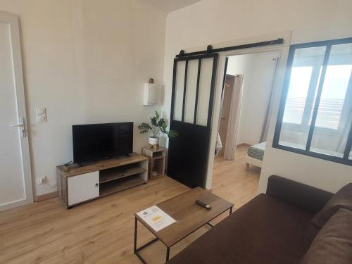 a living room with a couch and a flat screen tv at L'Oasis in Fos-sur-Mer