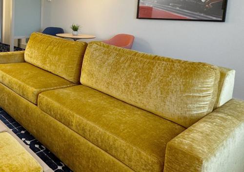 a yellow couch sitting in a living room at Colony House Motor Lodge in Roanoke