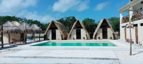 a swimming pool in front of a building at Maha Yaxja in Mahahual