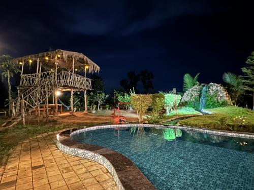 a resort with a swimming pool at night at Khet - A Rural Farmstay in Jagdalpur