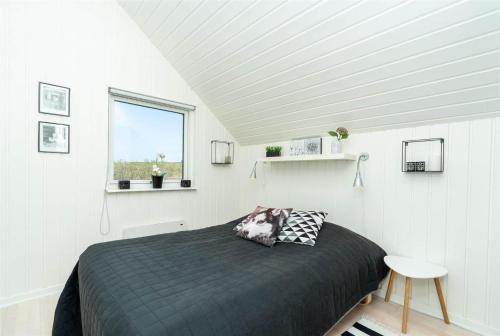 a bedroom with a bed in a white room at 272-Ringkobing-Vestklitvej-22 in Klegod