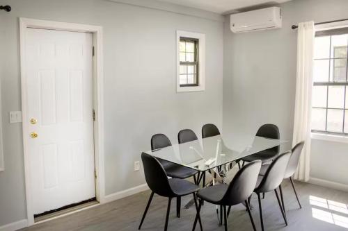 a white dining room with a glass table and black chairs at Modern 3 Bed House in Black Rock in Bridgeport