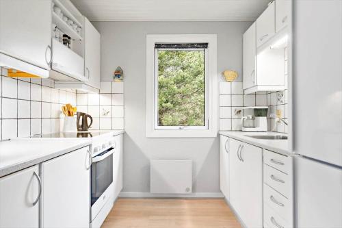 Una cocina con gabinetes blancos y una ventana. en 127-Ringkobing-Birkealle-1, en Nørby