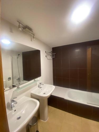 a bathroom with a sink and a tub and a toilet and a mirror at Casa Menor - Mar Menor Golf in Torre-Pacheco