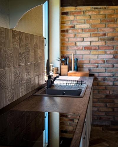 a kitchen with a sink and a brick wall at Stone House Bran in Bran