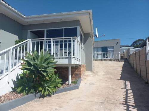 a house with a white railing and a porch at 7 Diaz Street Da Nova in Mossel Bay