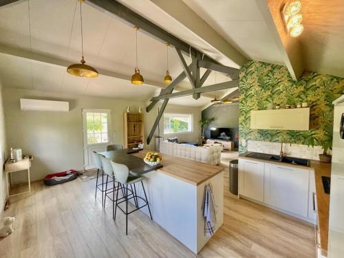 Les ChampeauxにあるVilla été , chalet hiver près de Camembert avec jacuzzi et piscine chauffée 15 avril au 1er octobreのテーブルと椅子のあるキッチンとリビングルーム