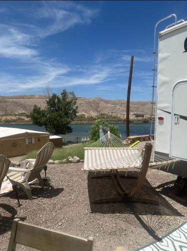 a table and chairs sitting next to a trailer at Fisher Paradise Oasis on the River in Bullhead City