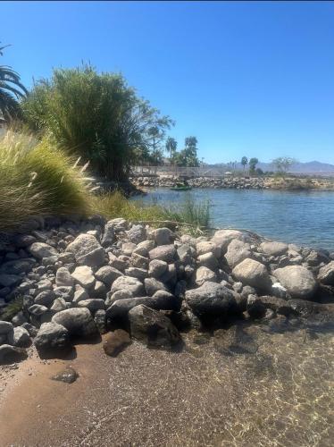 a group of rocks on the shore of a river at Fisher Paradise Oasis on the River in Bullhead City