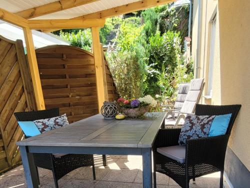 a table and chairs on a patio with a pergola at Ahrtal Vier Sterne Ferienwohnungen Alexandra Weiler Ferienwohnung Harmonie in Bad Neuenahr-Ahrweiler