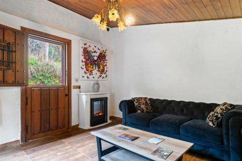 a living room with a blue couch and a fireplace at El Bosque in Candamo
