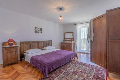 - une chambre avec un lit et une couverture violette dans l'établissement Villa John, à Pula