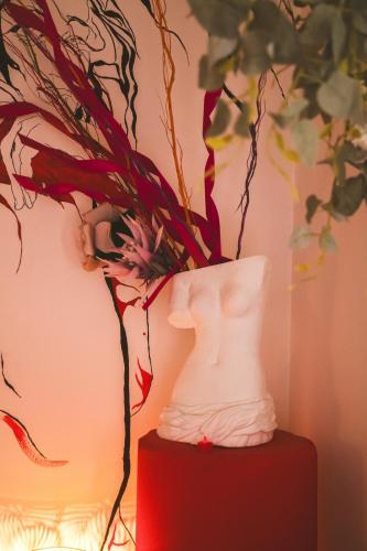a white vase sitting on top of a red table at Lunar artistic loft in Pisa