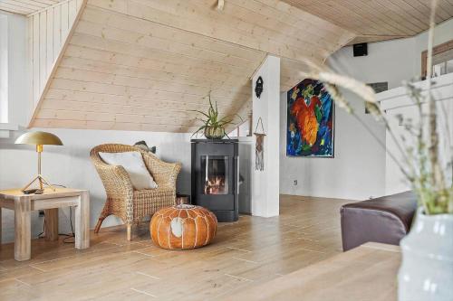 a living room with a wood stove and a chair at 1126-Ringkobing-Frans-Julius-Vej-44 in Ringkøbing