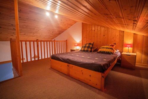 une chambre avec un lit dans une pièce en bois dans l'établissement Résidence Cristallin G - CRISTALLIN 56 MAE-5901, à Valmorel