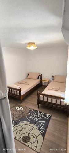 a room with two beds and a rug at AB Guest House in Pogradec
