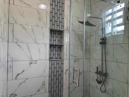 a bathroom with a shower with white marble walls at Casa Finca El Encanto in Arroyo El Cabo