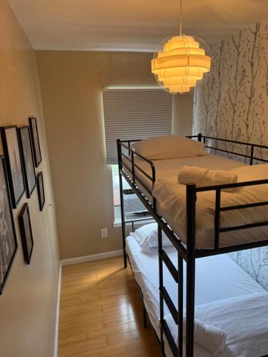 a bedroom with two bunk beds and a chandelier at Liberty Dream - 20 min to NYC in Jersey City
