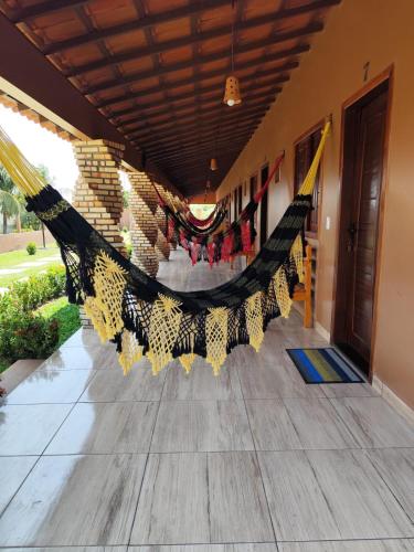 a room with a hammock on the floor at Pousada Brisa das Dunas in Paulino Neves