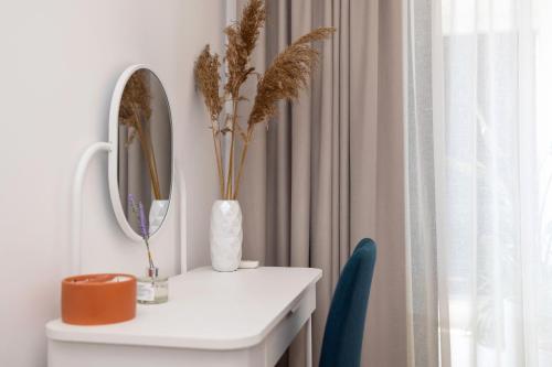 a white table with a mirror and a vase with plants at Seaside Escape in Split
