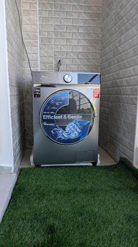 a washing machine sitting on the grass in a garage at Luxury Sea View Hideaway - Steps from Nyali Beach in Mombasa