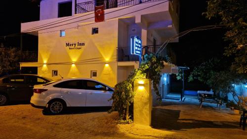 a white car parked in front of a building at night at Mery Inn in Pamukkale