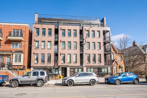 three cars parked in a parking lot in front of a building at Peaceful 2BR Basement Suite Near Downtown Toronto - The Roland in Toronto