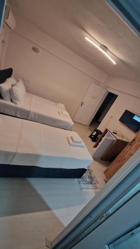 a room with two beds and a desk with a computer at Mery Inn in Pamukkale
