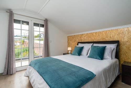 een slaapkamer met een groot bed en een groot raam bij Barreiro View in Ribeira Brava