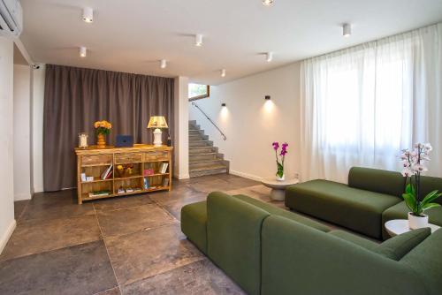 a living room with a green couch and a staircase at Montelleri Residenza di Campagna in Vicchio