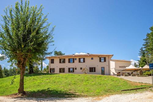 a house on a hill with a tree in front of it at Montelleri Residenza di Campagna in Vicchio