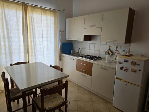 Una cocina con una mesa y un refrigerador blanco. en T0 Bounty, en Santa Maria